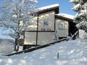 eine Hütte im Schnee mit schneebedeckten Bäumen in der Unterkunft Ferienwohnung Vogel in Siegsdorf