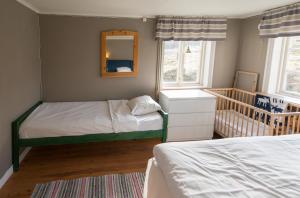 a bedroom with two beds and a mirror and a crib at Lilla Trulsabo in Skillingaryd