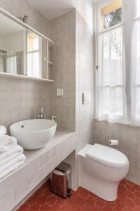 La salle de bains blanche est pourvue d'un lavabo et de toilettes. dans l'établissement Seaside Studio by iCasamia, à Nice