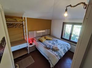ein kleines Schlafzimmer mit einem Bett und einem Fenster in der Unterkunft B&B Taccu Maccu in Ulassai