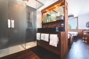 a bathroom with a shower and a sink and a mirror at Alpine Hotel by SnowWorld in Landgraaf