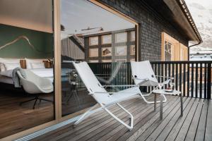 two chairs and a glass table on a balcony at Berghotel Biberkopf in Warth am Arlberg