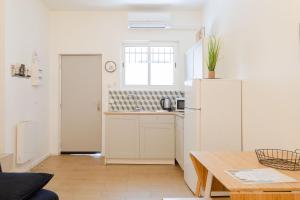 a kitchen with a white refrigerator and a table at Studio Family Marseille Parking Clim - MaisonMars in Marseille