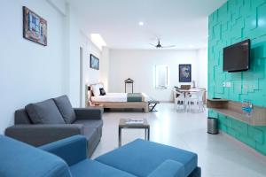 a living room with a couch and a bed at M Stays in Chennai