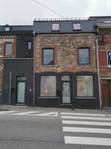 un edificio in mattoni con finestre e un passaggio pedonale su una strada di La Librairie a Francorchamps