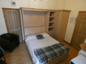 Dormitorio pequeño con cama y armario en Hurst Dene Aparthotel, en Swansea