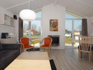 sala de estar con sofá, sillas y chimenea en 4 person holiday home in GROEMITZ, en Grömitz