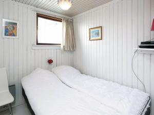 uma cama num pequeno quarto com uma janela em Three-Bedroom Holiday home in Faaborg 3 em Faaborg