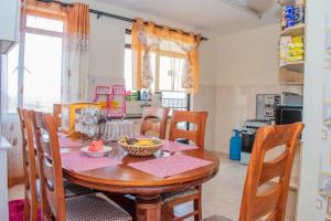 een keuken met een houten tafel met stoelen en een tableasteryasteryasteryasteryasteryastery bij JKIA homestays in Nairobi