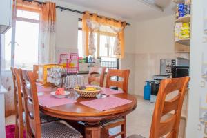 ナイロビにあるJKIA homestaysのキッチン(木製テーブル、椅子、テーブルスターヤーヤーヤーヤーヤードレステリ付)