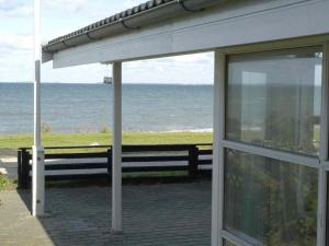 a building with a view of the ocean and a bench at 4 person holiday home in Otterup in Otterup