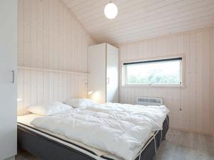 グローセンブローデにあるHoliday home Großenbrode XVIの窓付きの客室で、白い大型ベッド1台が備わります。