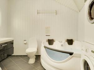 a bathroom with a toilet and a washing machine at 8 person holiday home in Hemmet in Hemmet