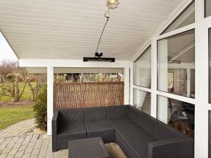 un porche cubierto con un sofá negro en 8 person holiday home in Hemmet, en Hemmet
