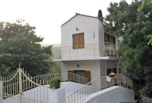 a white house with stairs leading up to it at LAGADA HOLIDAY ROOMS in Lagkáda