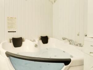 uma casa de banho branca com uma banheira. em 8 person holiday home in Hemmet em Hemmet