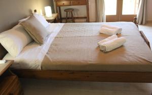 a bed with two towels on top of it at LAGADA HOLIDAY ROOMS in Lagkáda