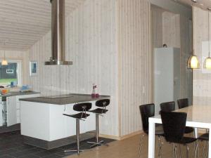 a kitchen with a counter and a table and chairs at 9 person holiday home in V ggerl se in Bøtø By