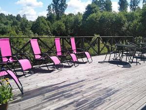 a bunch of pink chairs and tables on a deck at 8 person holiday home in GR NNA in Målskog