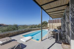a view of a swimming pool from the patio of a house at Porti Villas Aphrodite in Asómatoi