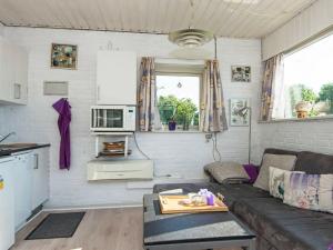 ein Wohnzimmer mit einem Sofa und einem Tisch in der Unterkunft One-Bedroom Holiday home in Gråsten in Rønsheved