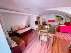 B&B Chiostro San Marco في تاركوينيا: غرفة معيشة مع طاولة وأريكة وسرير