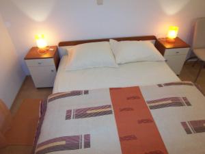a bedroom with two night stands with two candles on top of a bed at Apartments Croatia Brač in Supetar