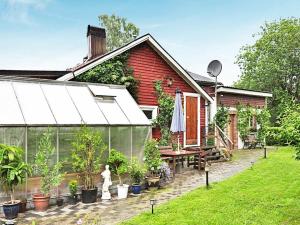 a greenhouse in front of a house with potted plants at 5 person holiday home in H SSLEHOLM in Hässleholm