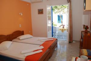 a bedroom with two beds and a door to a patio at To Steno in Kamares