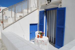 uma porta azul e uma mesa com flores em To Steno em Kamari