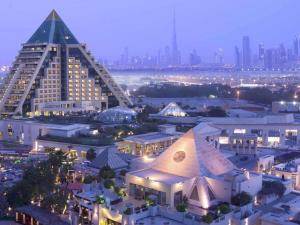 a large building with a pyramid in front of a city at Raffles Dubai in Dubai