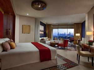 - une chambre avec un grand lit et un salon dans l'établissement Raffles Dubai, à Dubaï