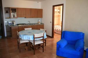 a kitchen with a table and a blue chair at Appartamento Gio B in Tignale