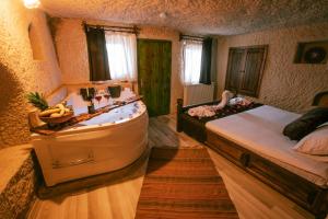 a hotel room with a bed, chair and a mirror at Mia Cappadocia Cave Hotel in Göreme