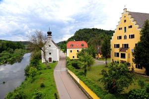 widok na rzekę z budynkami i kościołem w obiekcie Hotel Schlossresidenz Heitzenhofen w mieście Duggendorf