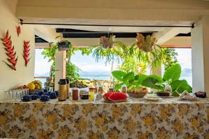 a table with food on it in front of a window at Pousada Sobre As Ondas de Picinguaba in Picinguaba
