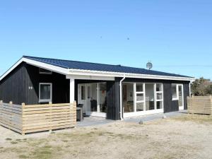 ein Schwarz-Weiß-Haus mit einer Veranda in der Unterkunft 10 person holiday home in Harbo re in Harboør