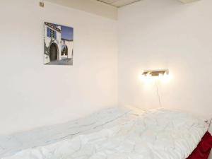 a white bed in a room with a picture on the wall at 4 person holiday home in Faaborg-By Traum in Bøjden