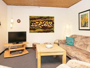 een woonkamer met een bank en een tv bij 6 person holiday home in Sp ttrup in Spottrup