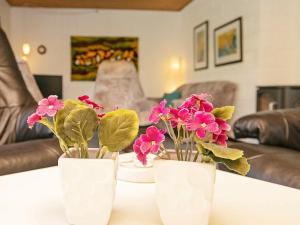 drie witte vazen met roze bloemen op een tafel bij 6 person holiday home in Sp ttrup in Spottrup