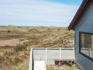 a bench sitting next to a building with a window at 6 person holiday home in Henne in Henne Strand