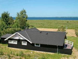 a black house in the middle of a field at Three-Bedroom Holiday home in Højslev 4 in Bøstrup