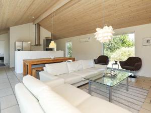 a living room with a white couch and a table at 8 person holiday home in lb k in Ålbæk