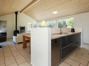 a kitchen with a sink and a living room at 8 person holiday home in lb k in Ålbæk