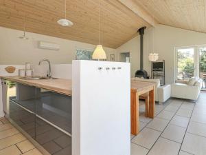 a kitchen with a white refrigerator and a table at 8 person holiday home in lb k in Ålbæk