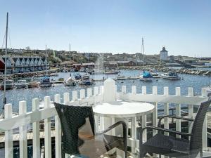 een balkon met een tafel en stoelen en uitzicht op een jachthaven bij 6 person holiday home in Hasle in Hasle