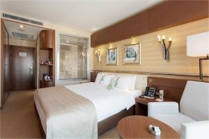 a hotel room with a large bed and a chair at Holiday Inn Ankara-Kavaklidere, an IHG Hotel in Ankara