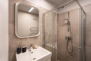 a bathroom with a sink and a shower with a mirror at Lovely apartment in the city center in Kaunas +35 photos