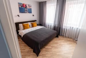 a bedroom with a bed and two windows at Lovely apartment in the city center in Kaunas