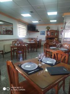 comedor con mesas y sillas de madera en Hotel Herranz, en Alcoroches